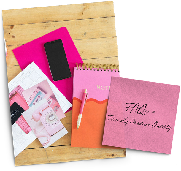 A wooden table topped with pink notebooks and a cell phone