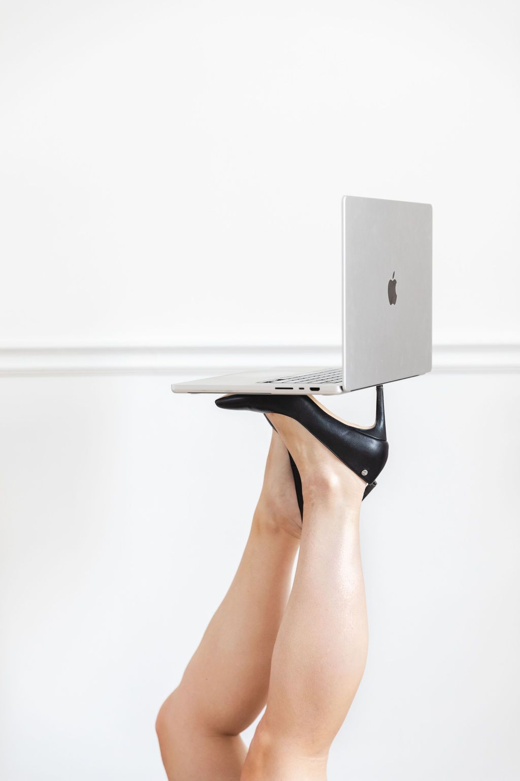 A woman is holding a laptop on her leg.