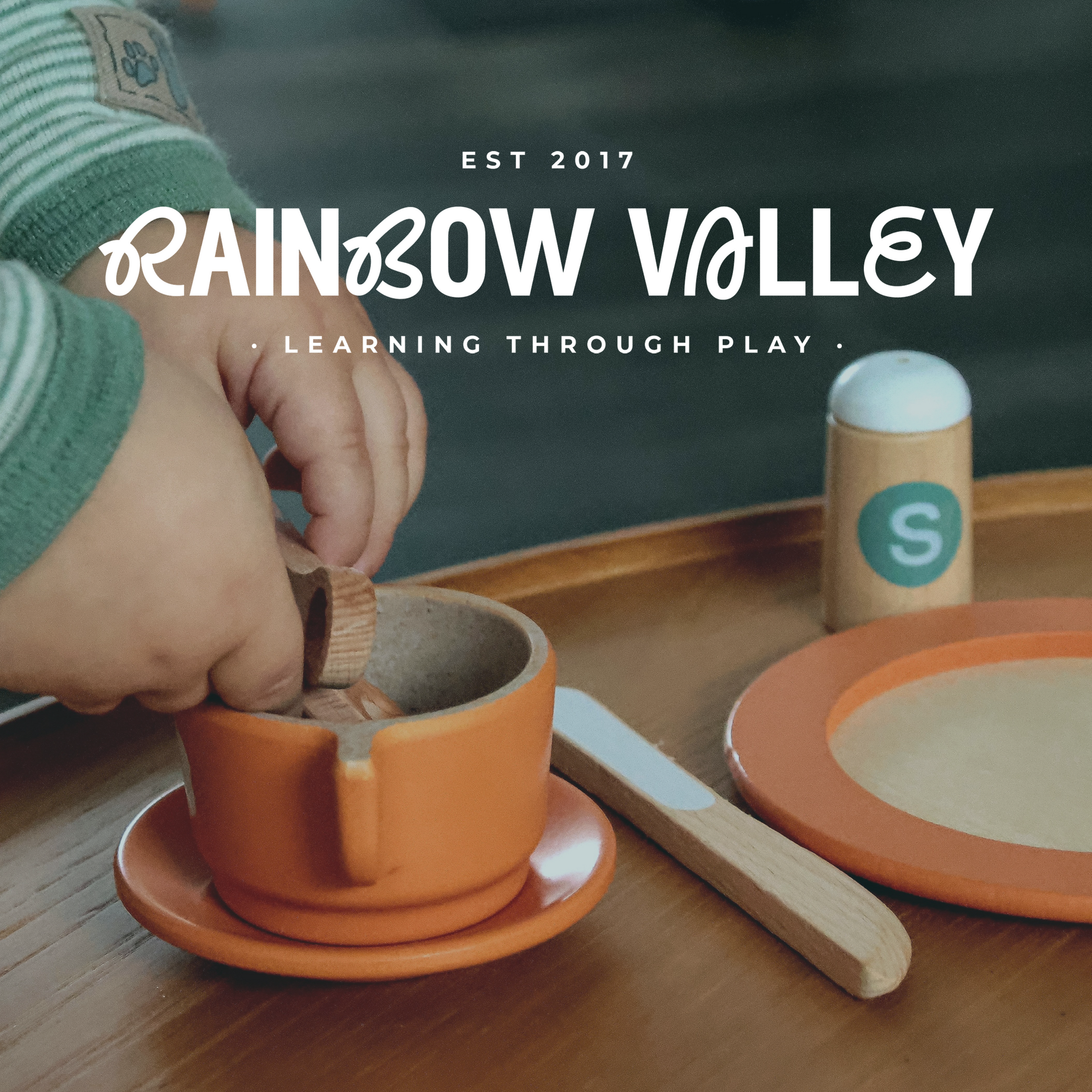 A baby playing with a wooden dish set. 