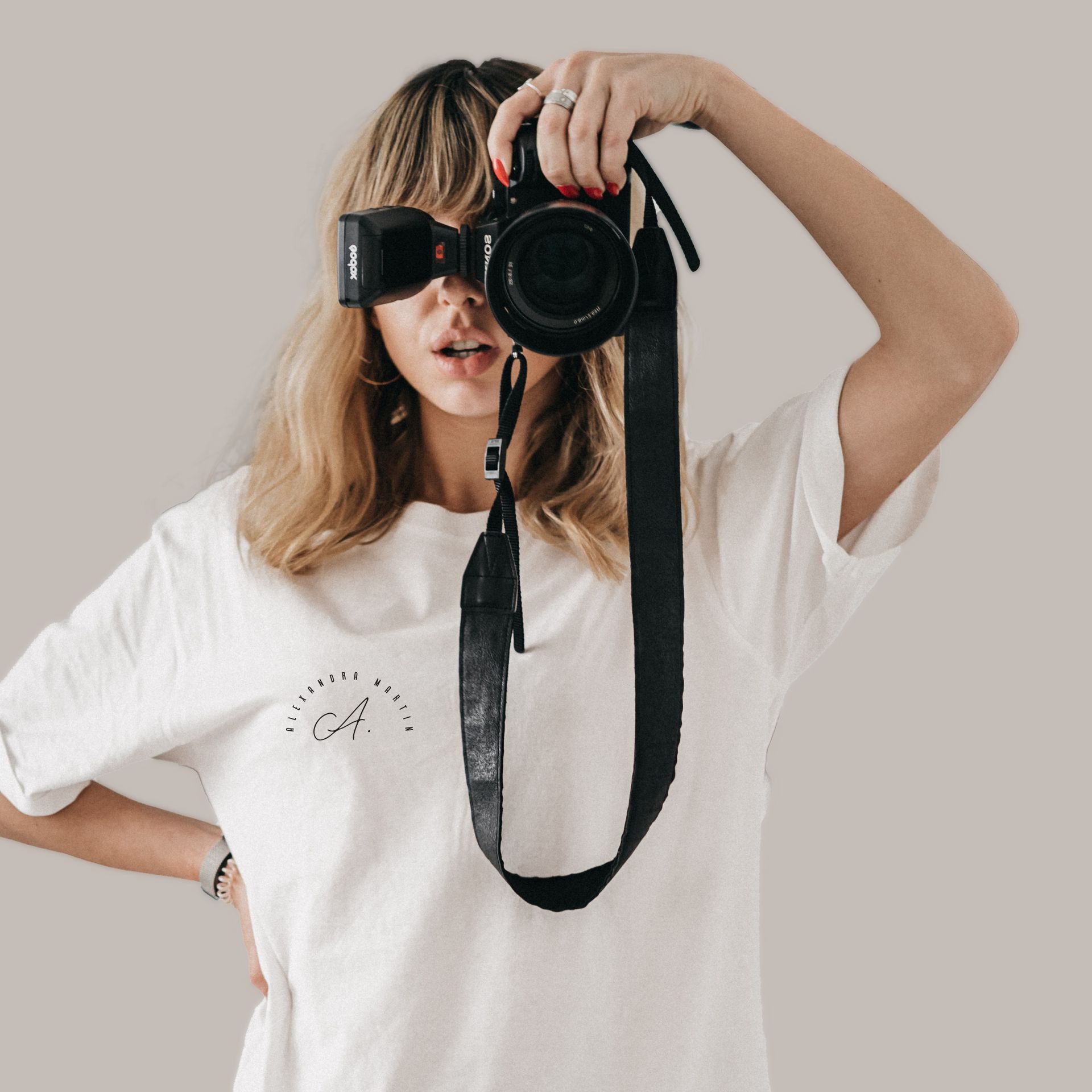 A woman in a white shirt is taking a picture with a camera