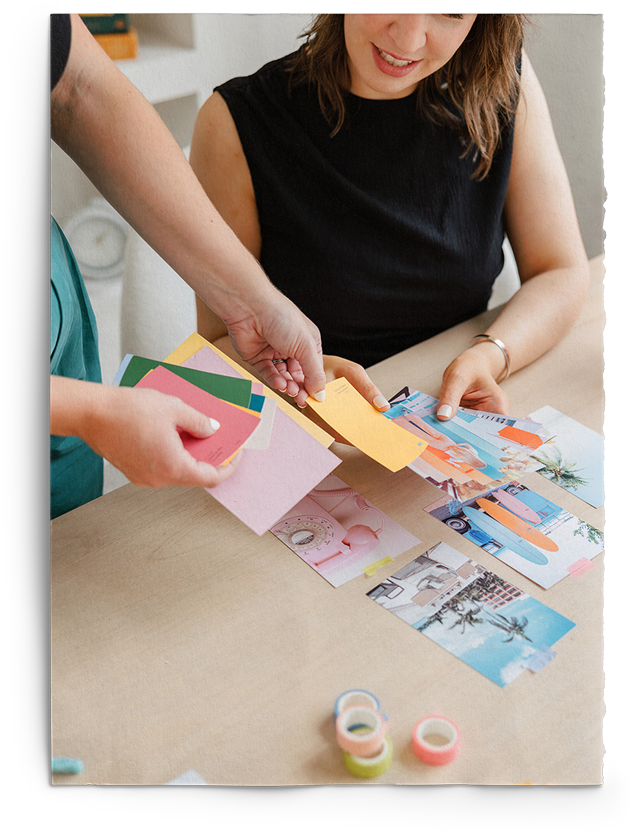Two women are sitting at a table looking at papers.