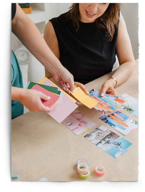 A woman is sitting at a table holding a piece of paper creating custom Branding