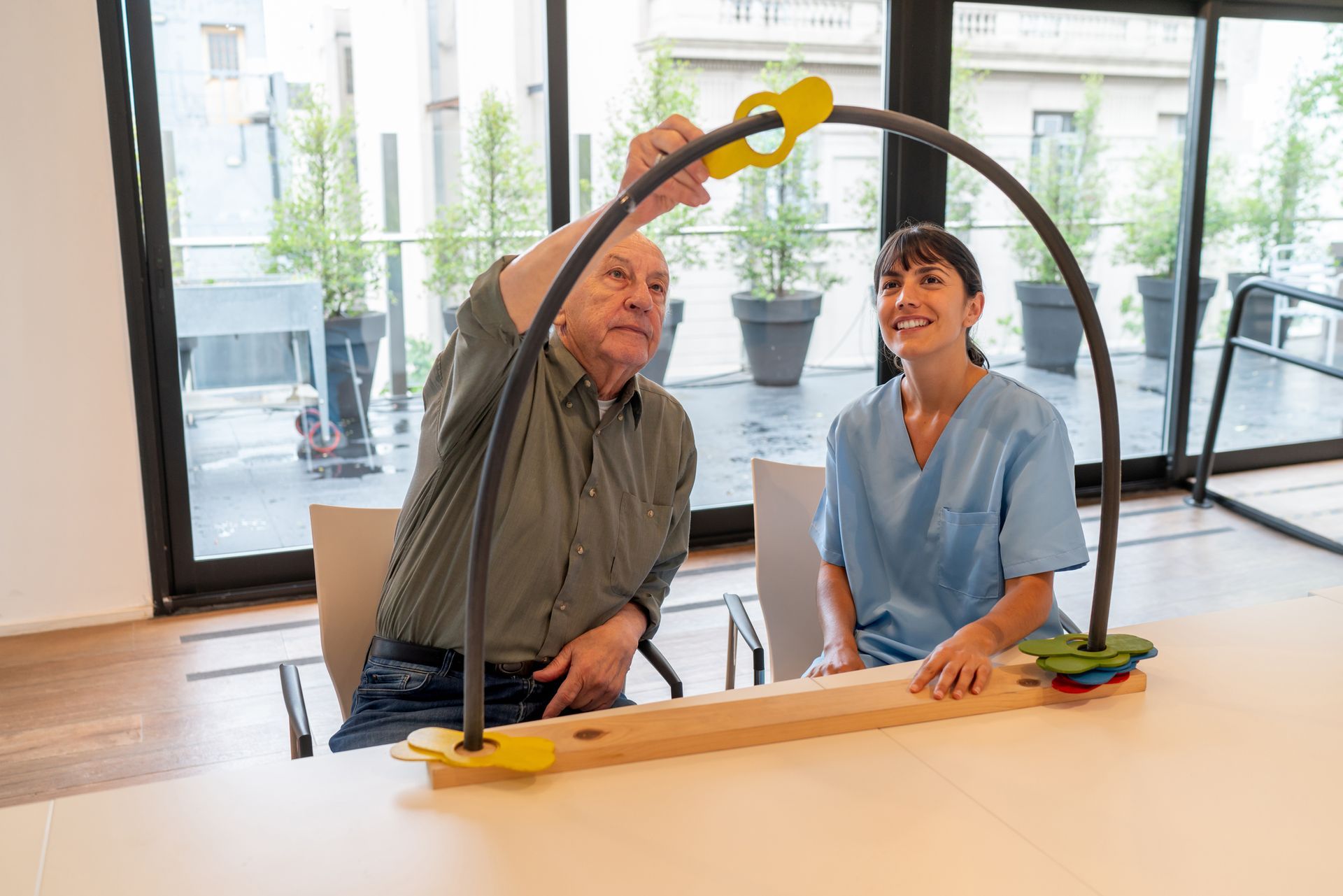 A man and a woman are sitting at a table playing with a toy.