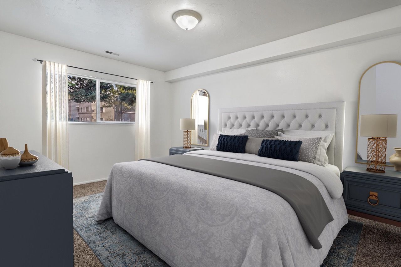 Bedroom in a modern apartment with a tufted headboard bed, two nightstands, and a window.