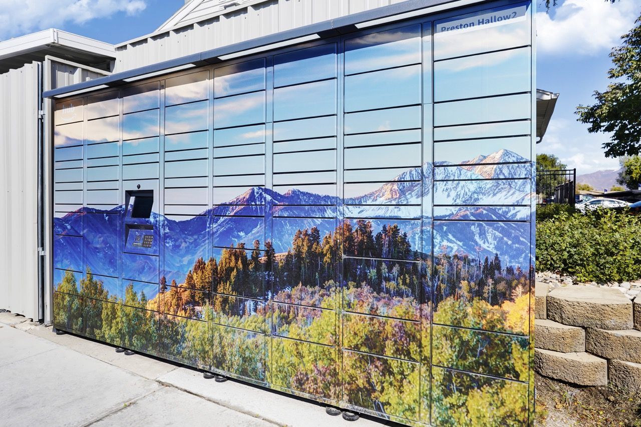 Exterior wall of a building with metal panels displaying a mountain landscape mural.