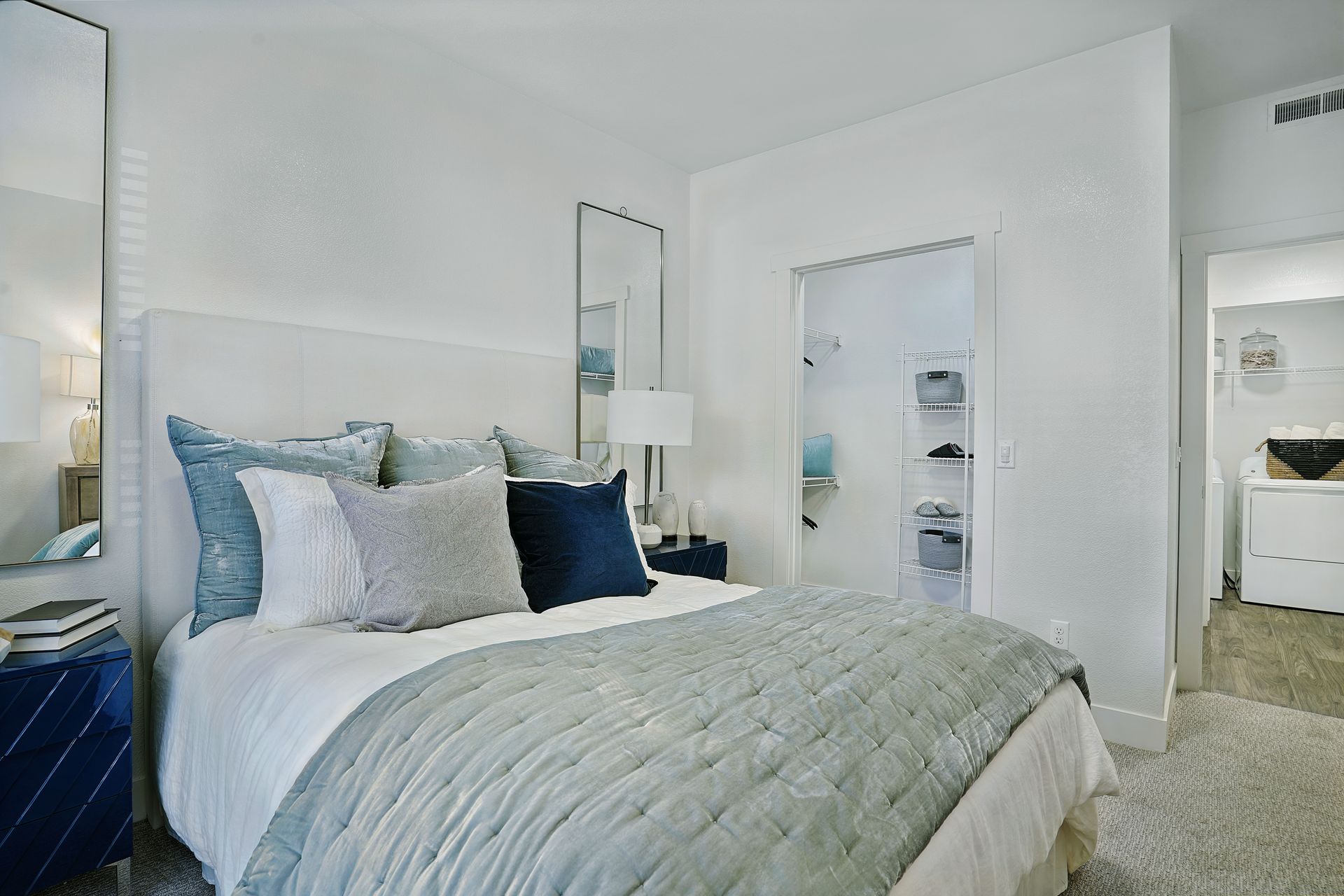 Bedroom with white walls, a bed with blue and white bedding, and a closet at Preston Hollow in Millcreek, UT.