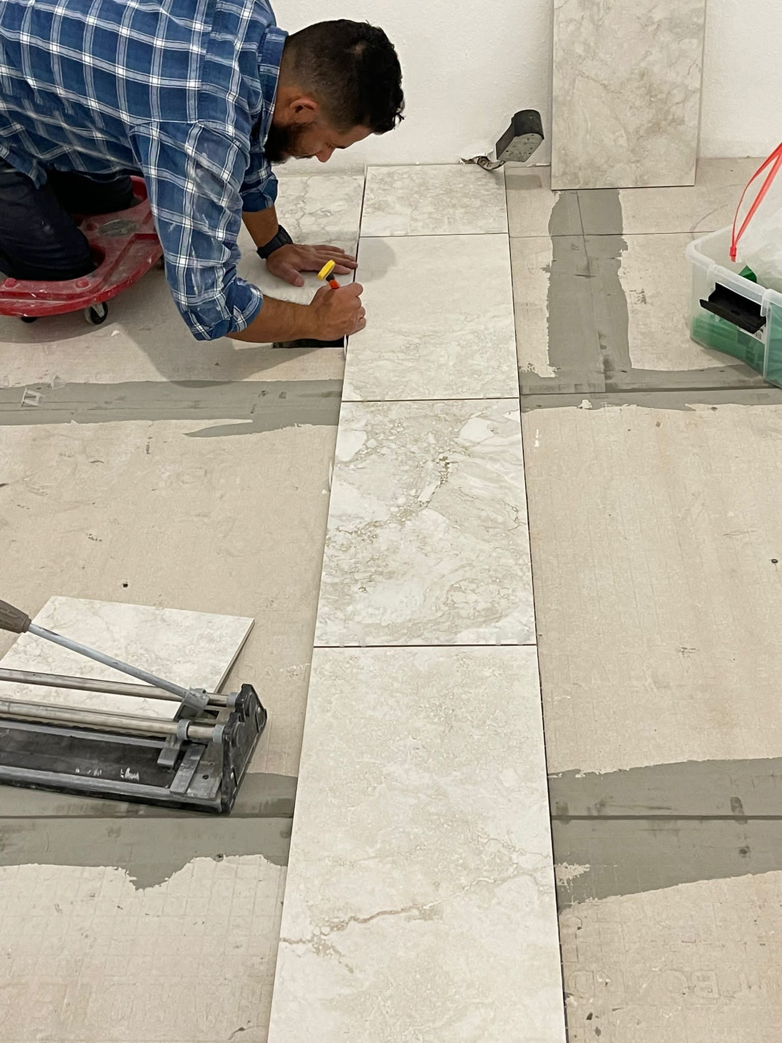 Tiler installing ceramic tiles using lever