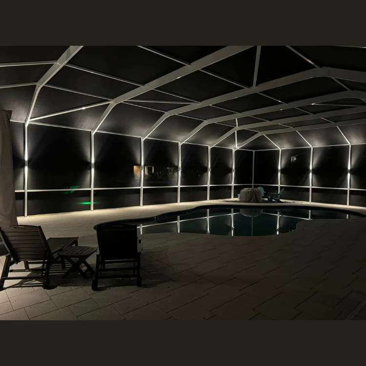 A large indoor swimming pool is lit up at night