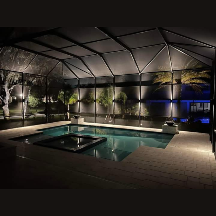 A large indoor swimming pool is lit up at night