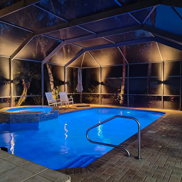 A large swimming pool is lit up at night