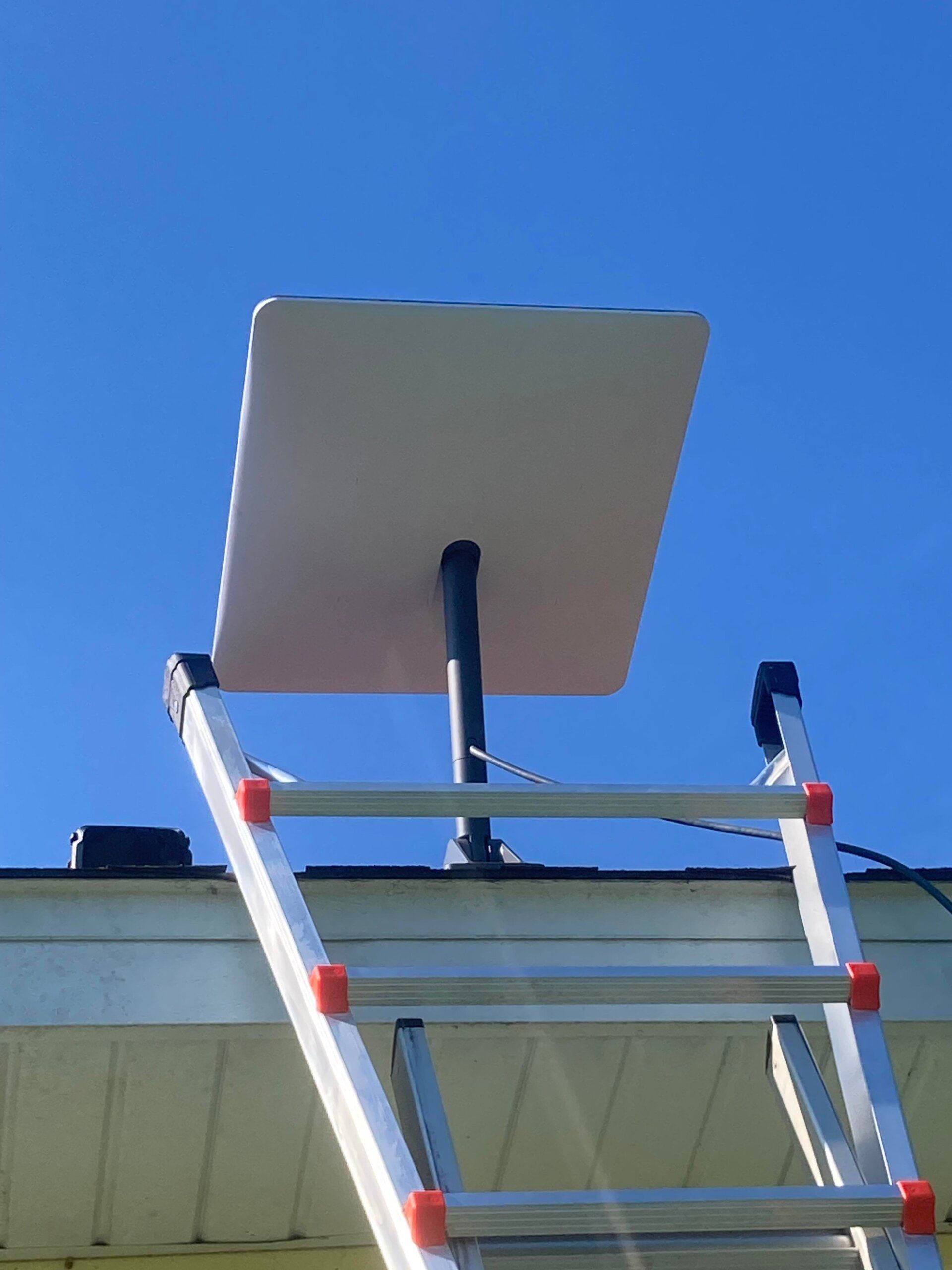 A ladder with a satellite dish on top of it