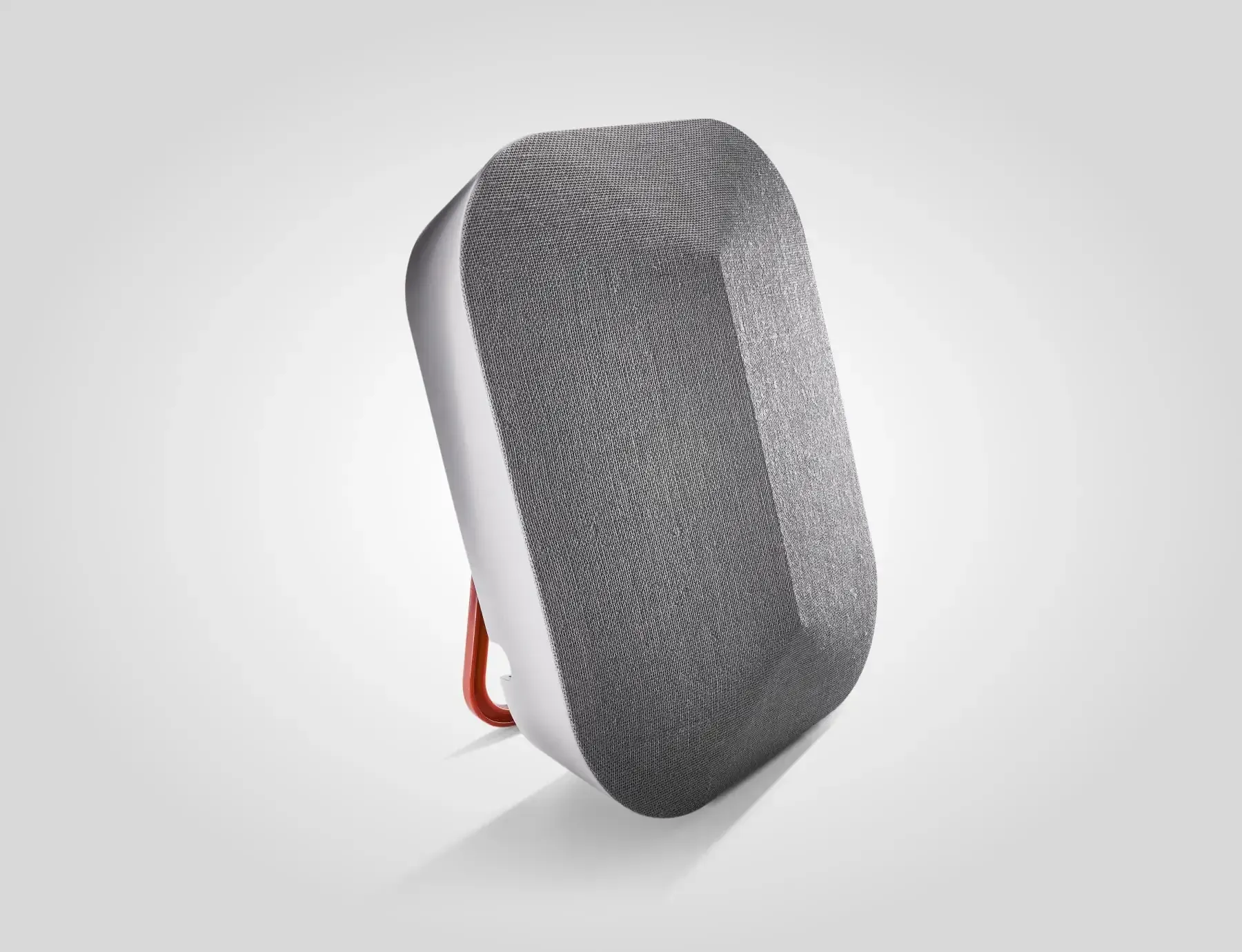 Gray, oblong speaker with silver trim and orange loop, against a white background.