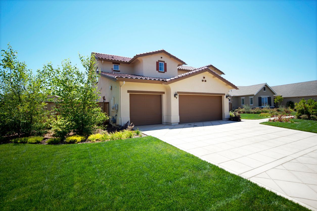 A large house with two garage doors and a driveway