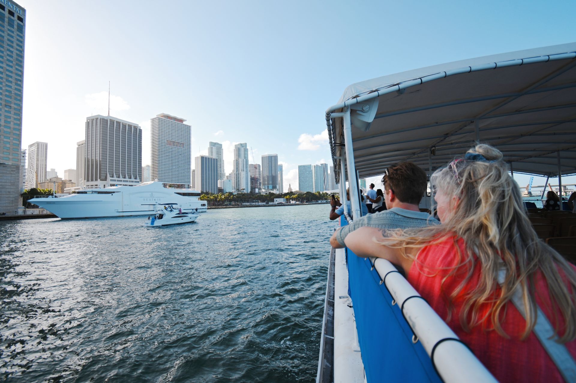 Couple enjoying the Star Island and Skyline Miami Boat Tour with yacht and skyline in view from Biscayne Bay