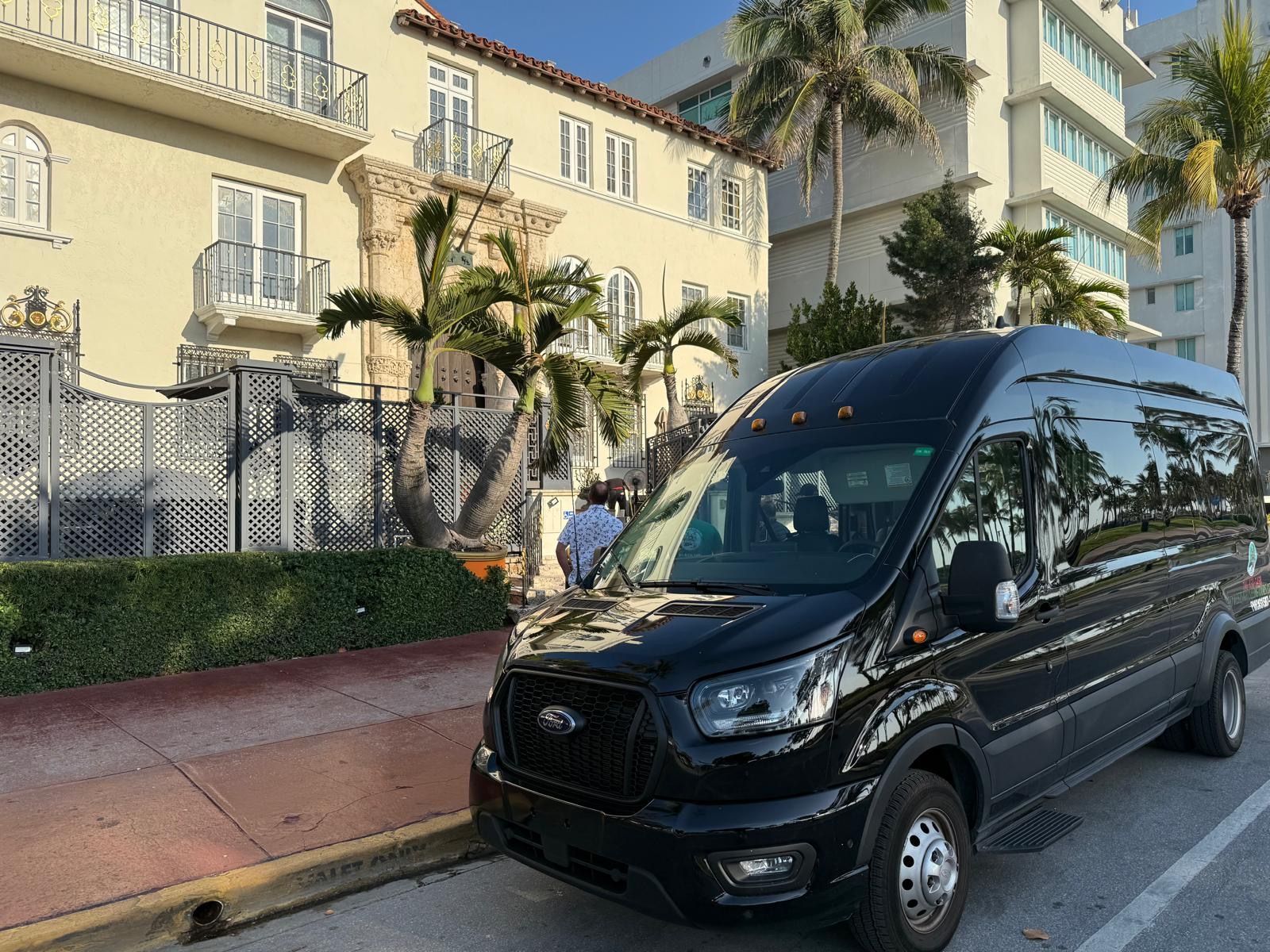 Black Miami Tour Bus parked in front of the Versace Mansion in Ocean Drive