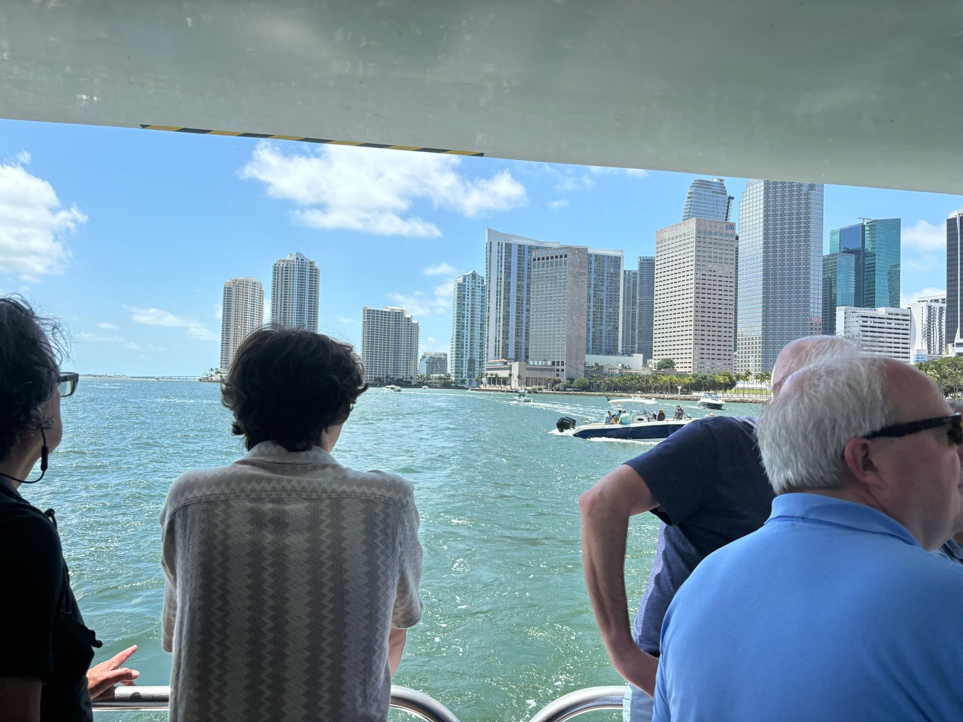 Guest in the back of the boat enjoying the Miami skyline during a Bayside boat cruise deal
