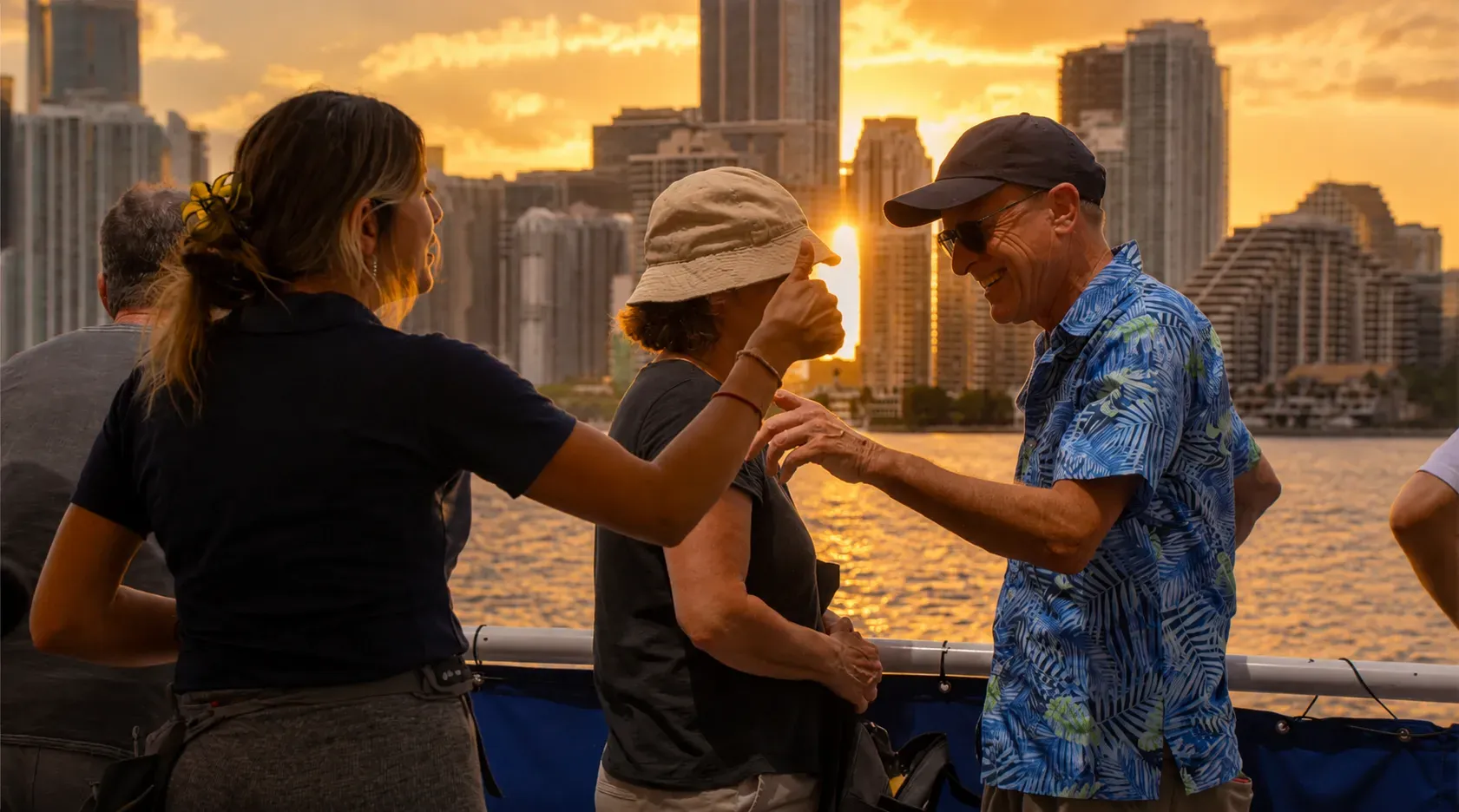 Crew member talking with passengers during a Miami Sunset Boat Ride while sharing local stories and sightseeing highlights.