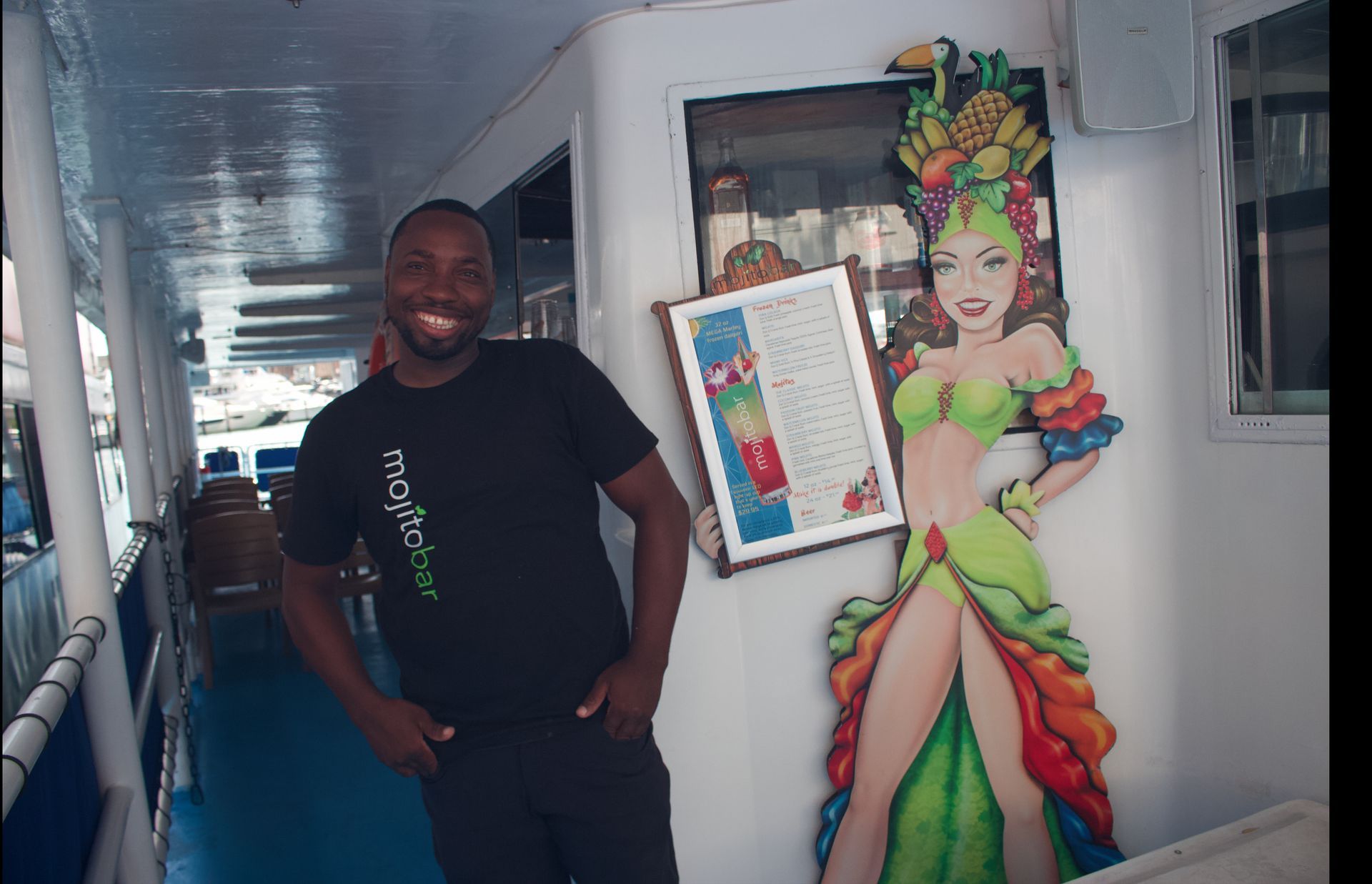 Professional bartender at the Mojito Bar onboard a Miami night cruise preparing drinks for guests.
