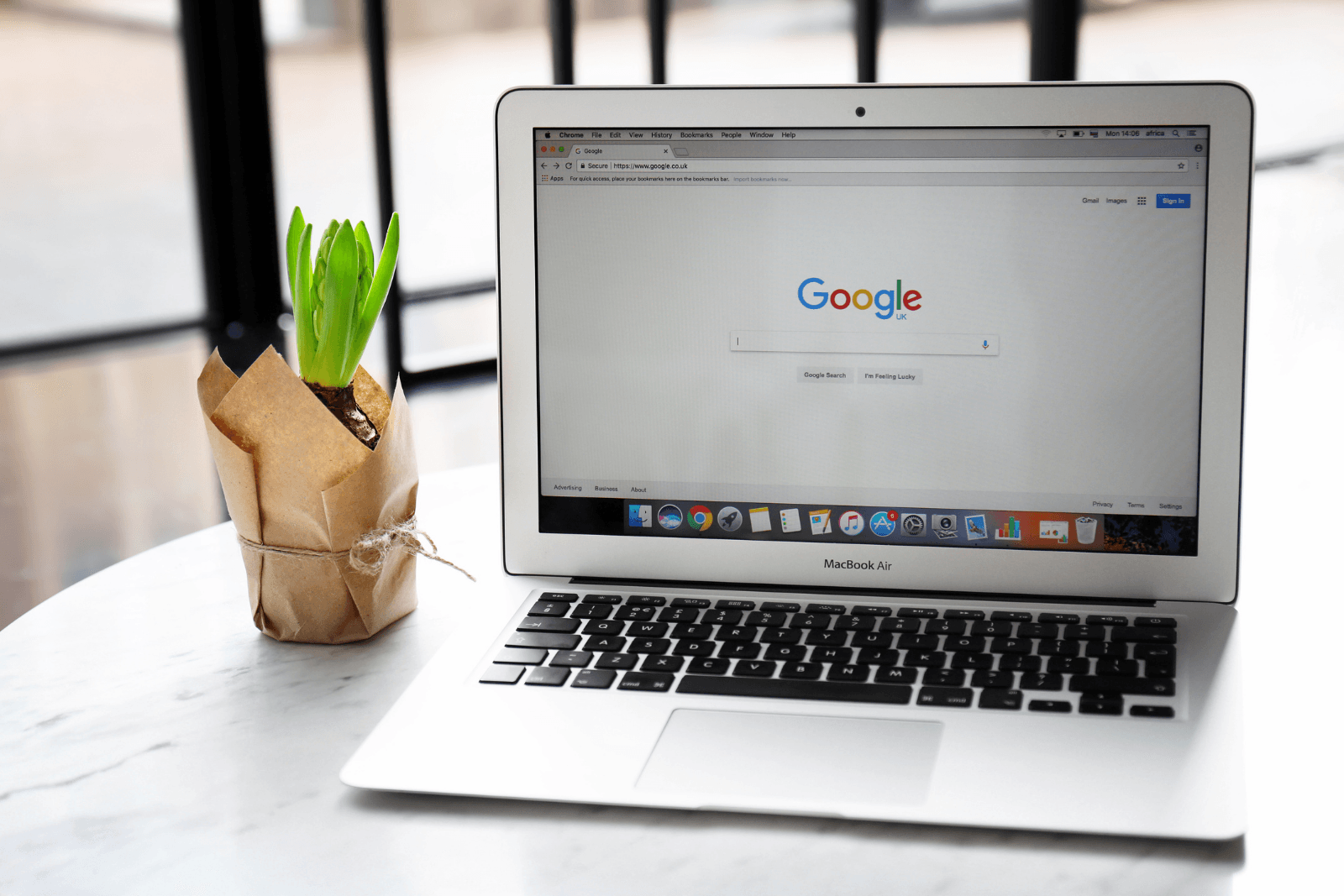A laptop computer is open to a google search page on a table.