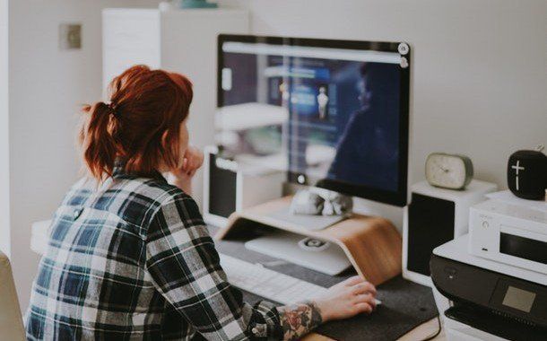 A woman is sitting at a desk in front of a computer.