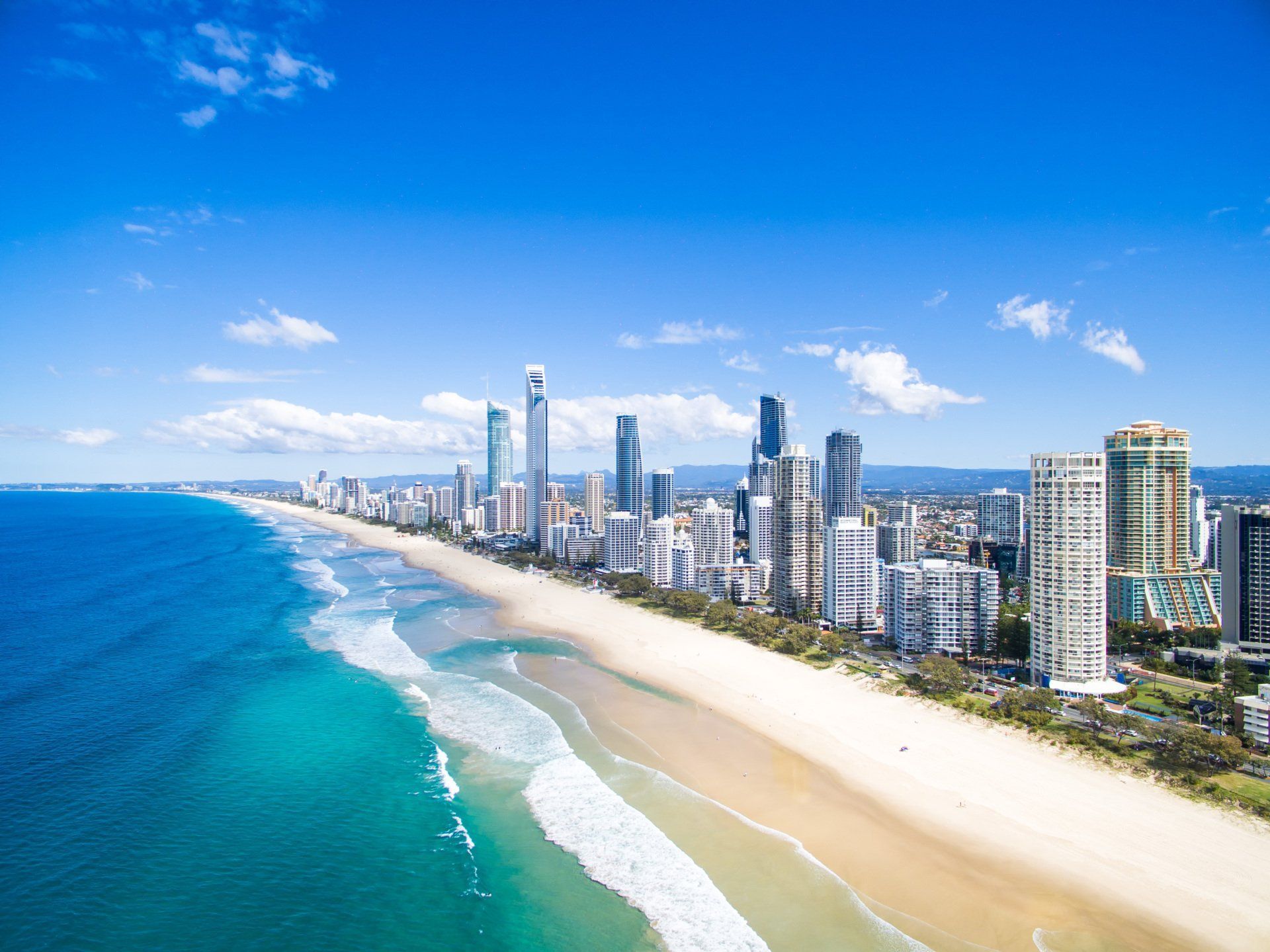 An aerial view of a beach with a city in the background.