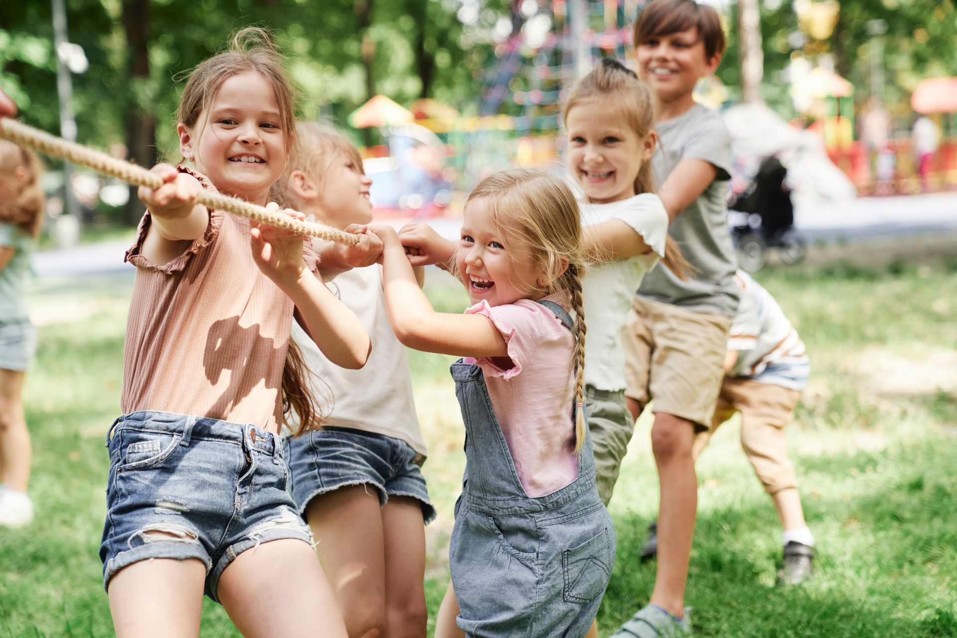A group of children are play tug of war