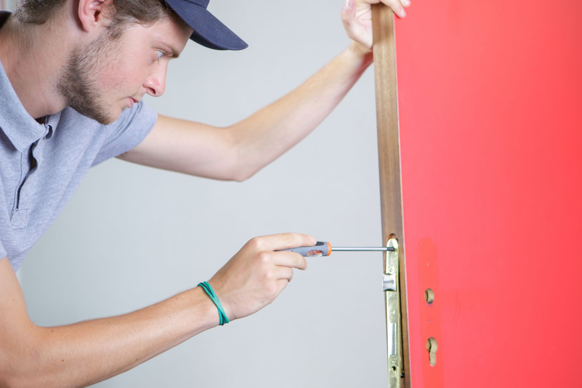 A locksmith picking a door lock during a residential service call.