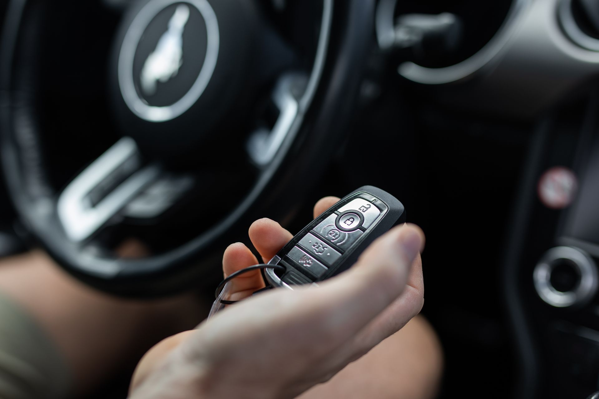 Car key fob holding caucasian hand male auto on off control drive.
