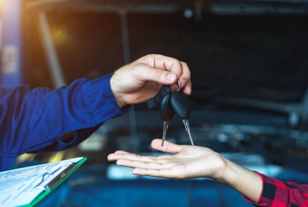 Tag-Mechanic handing over keys after FOB automotive key replacement service at repair shop