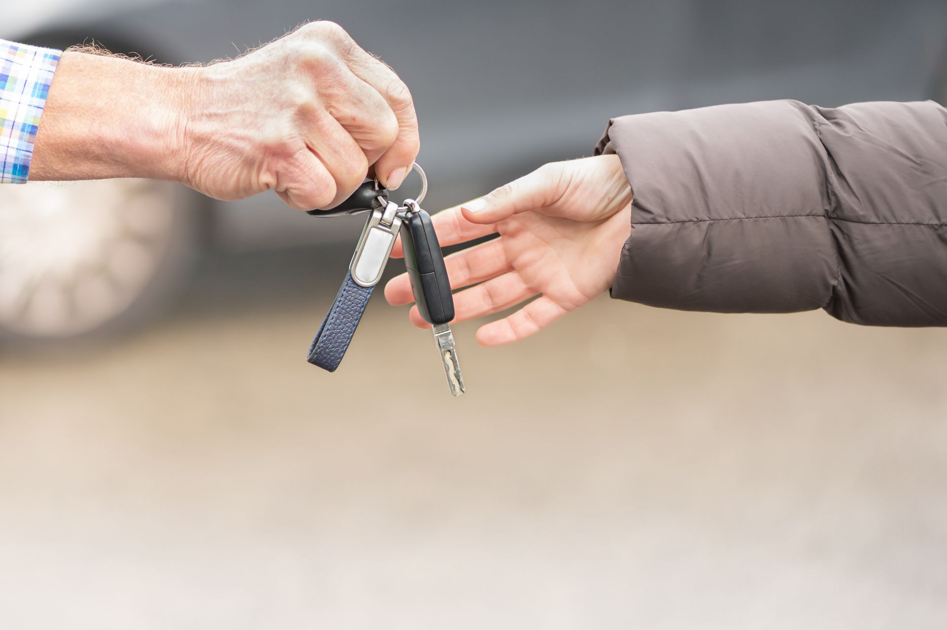 Car key hands over Businessman a young woman.