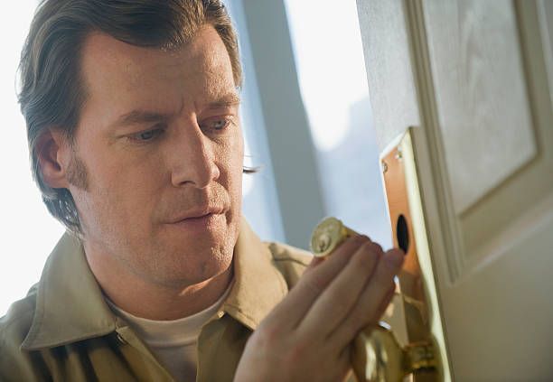Locksmith repairing door lock.