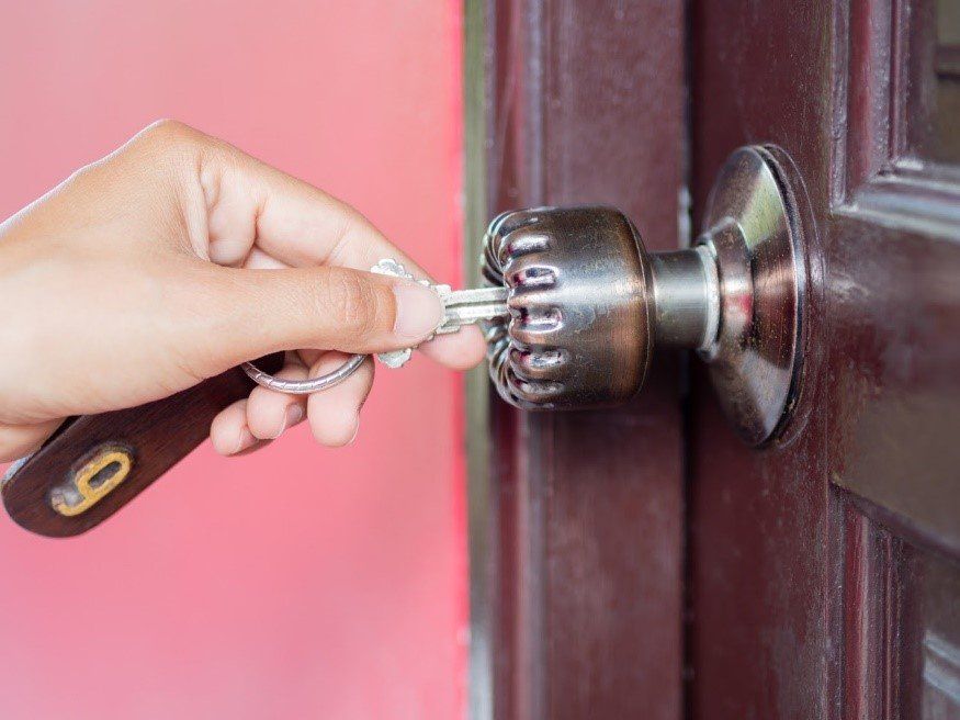 A Woman Opening A Door Using A Key — Menlo Park, CA — A-A Lock & Alarm Inc