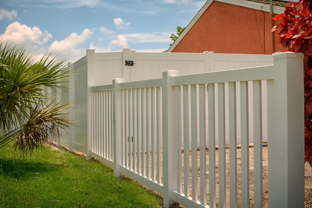 A White Fence is in Front of a Red House — Harbour Fencing In Moonee Beach, NSW