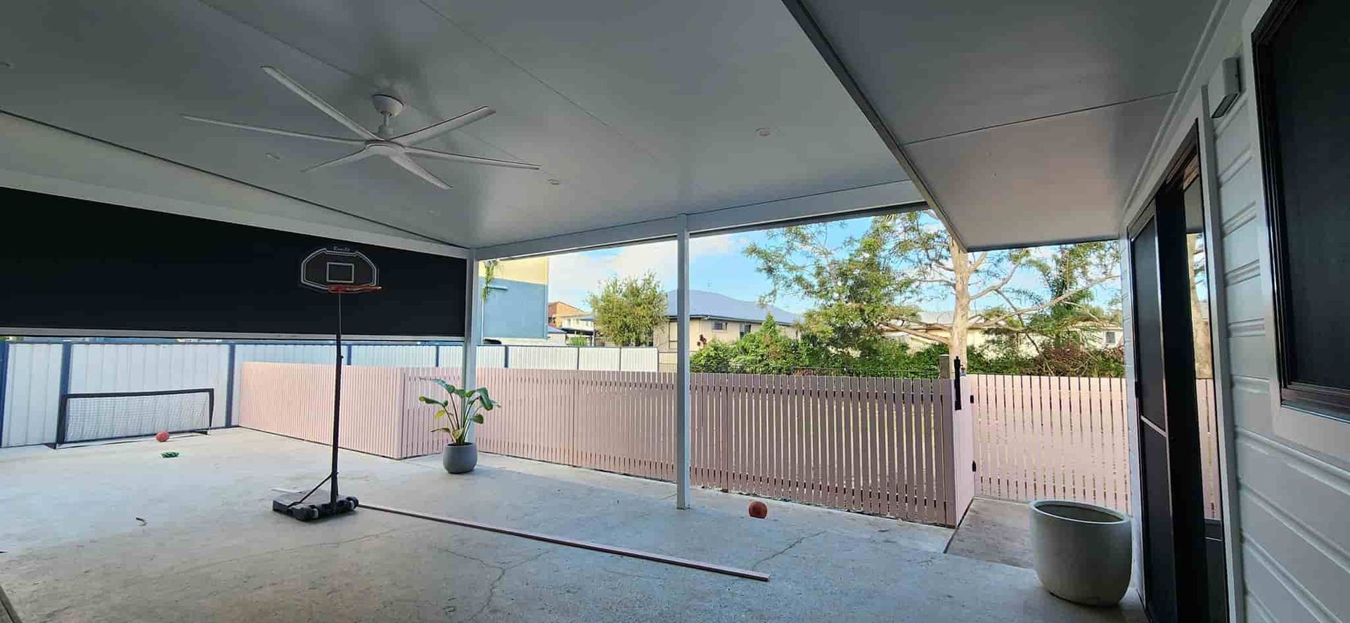 A Large Covered Patio With a Ceiling Fan and a Wooden Fence — Harbour Fencing In Moonee Beach, NSW