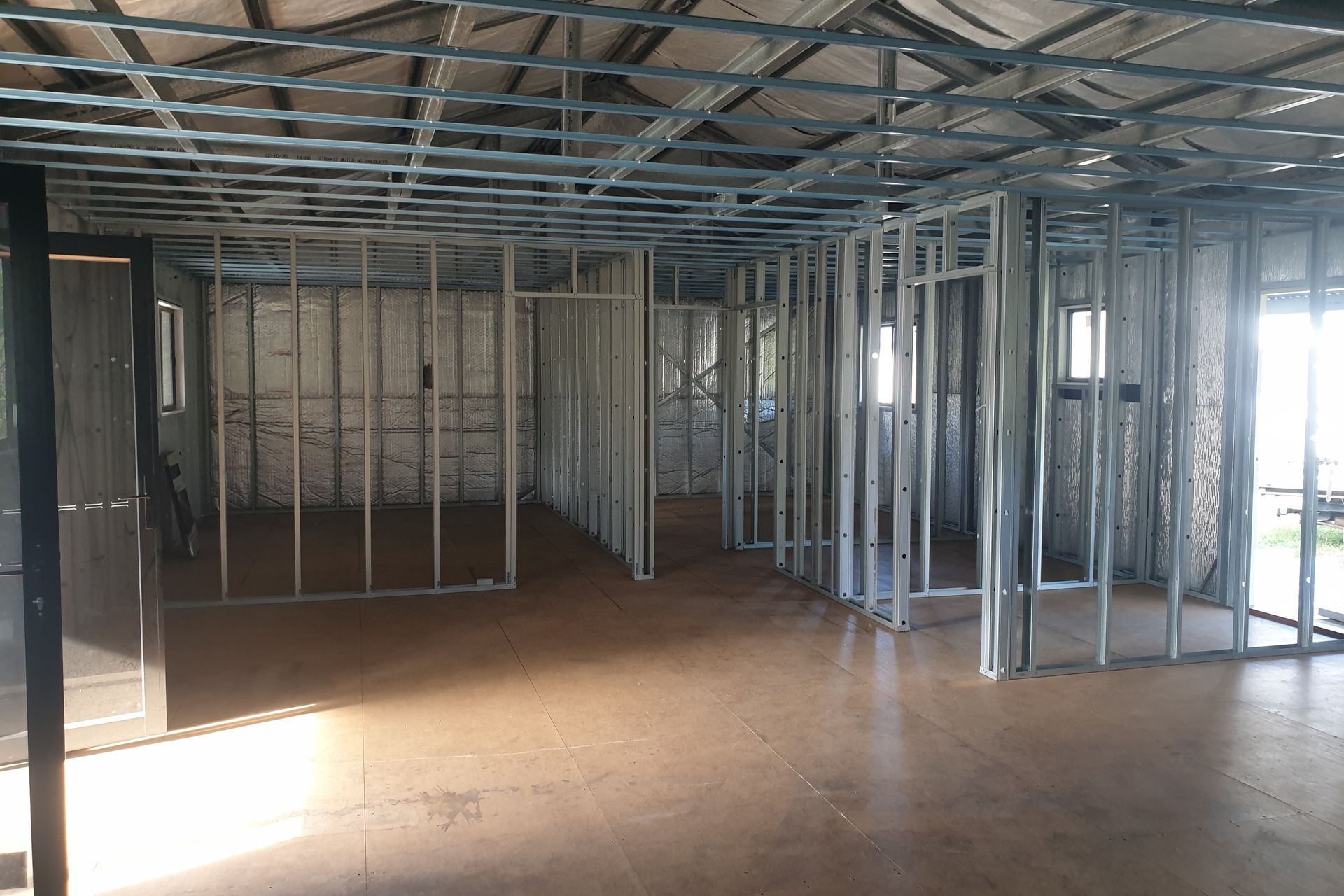 Interior of a building under construction, showing metal stud framing for walls and ceiling  — Steel Homes Australia in Branyan, QLD