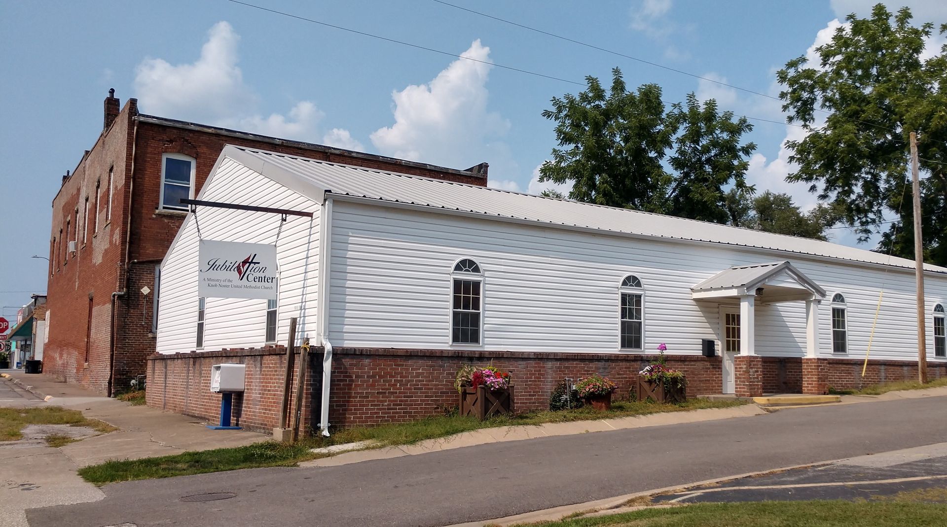 A large white building with a brick building behind it