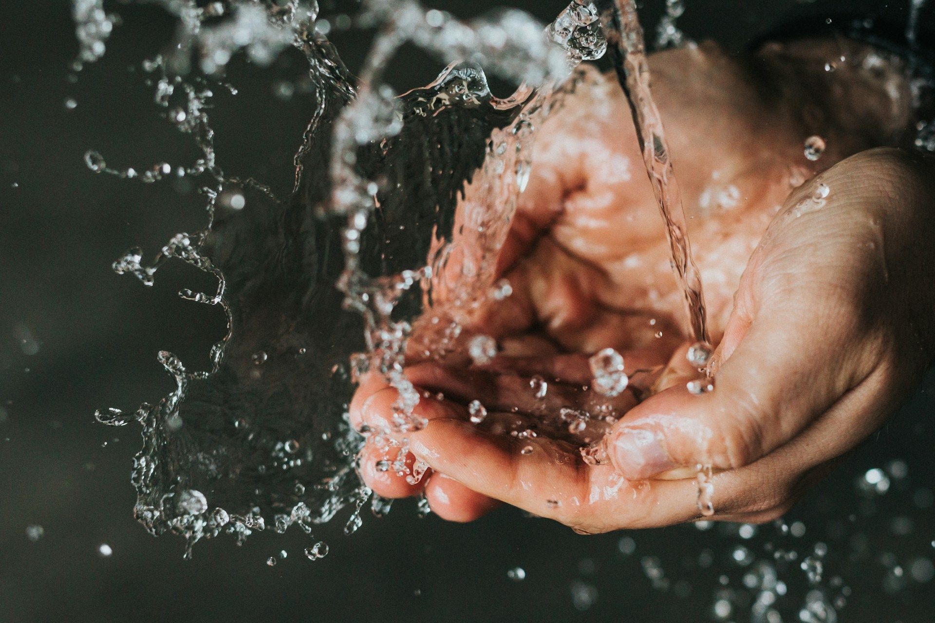 A person is holding water in their hands.