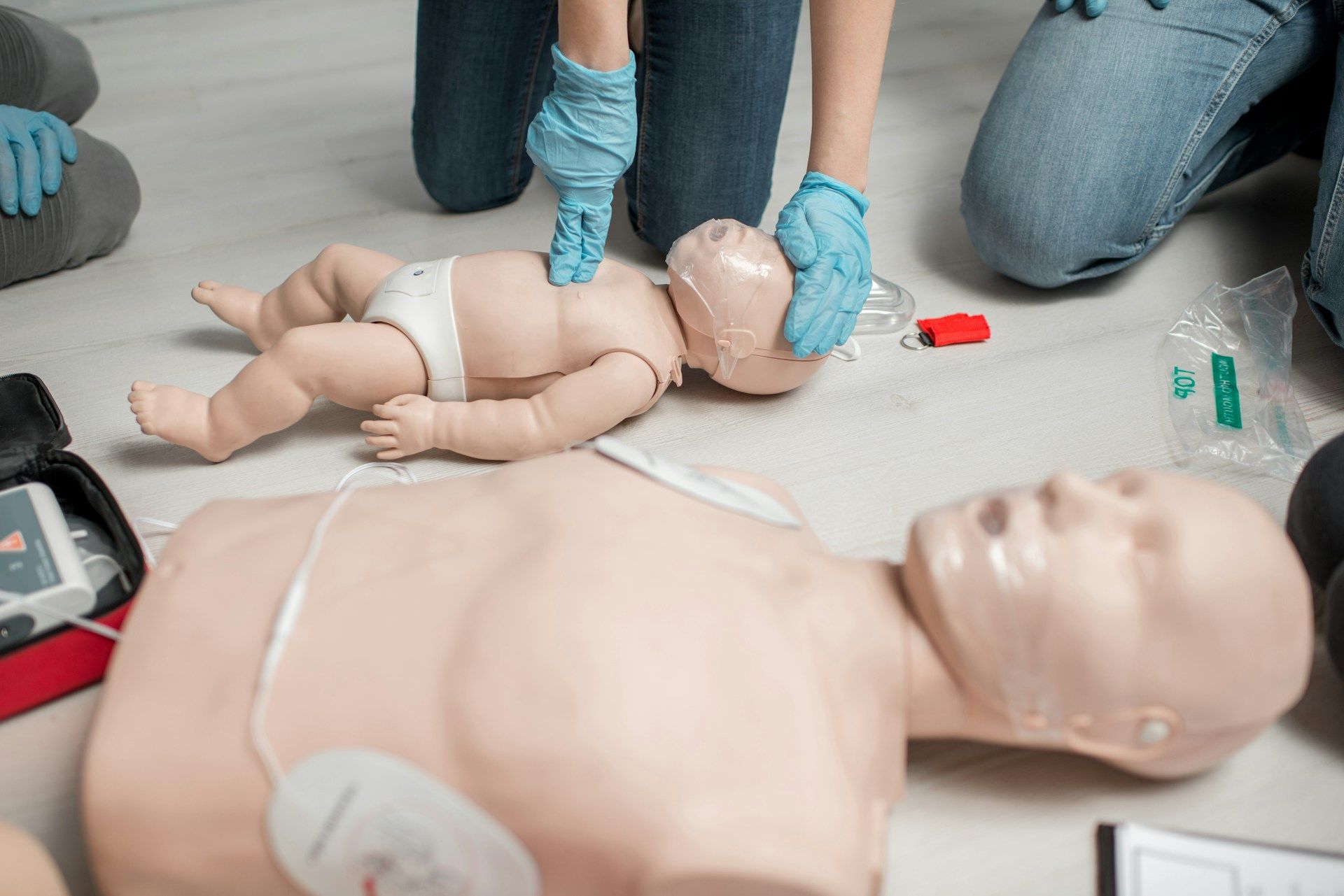 A group of people are practicing first aid on a mannequin.