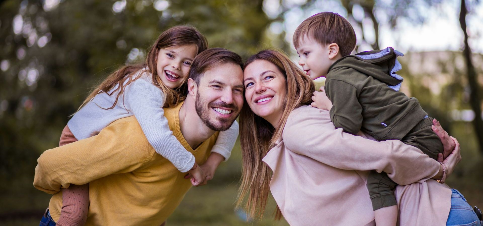 A family is posing for a picture in a park.