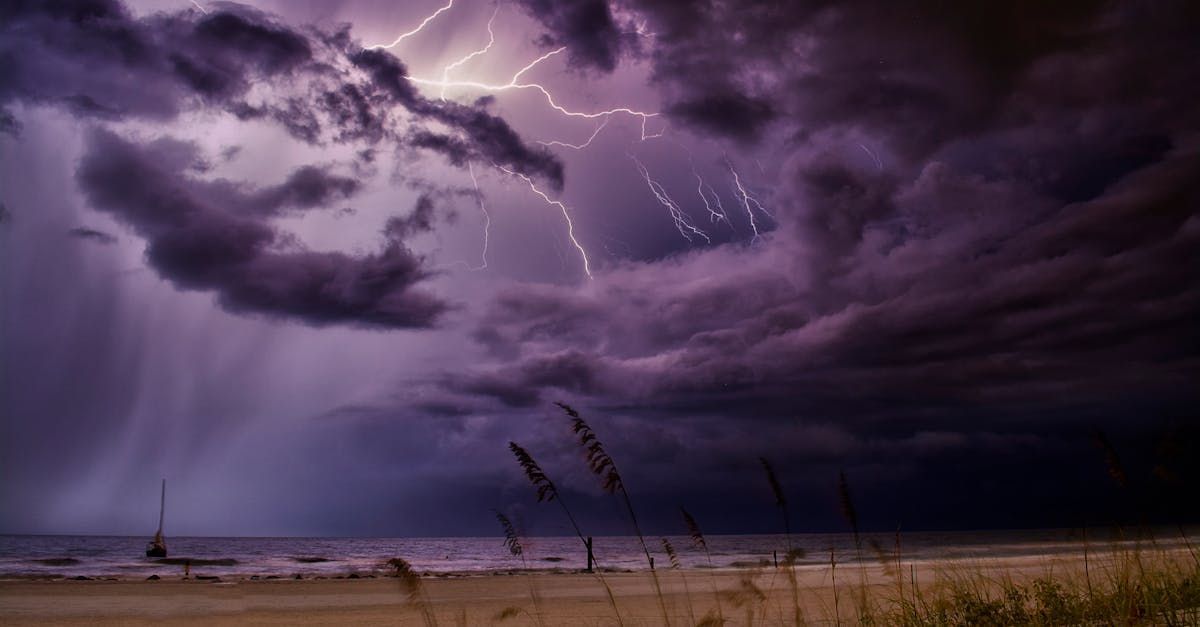 There is a lightning storm over the ocean with purple clouds.