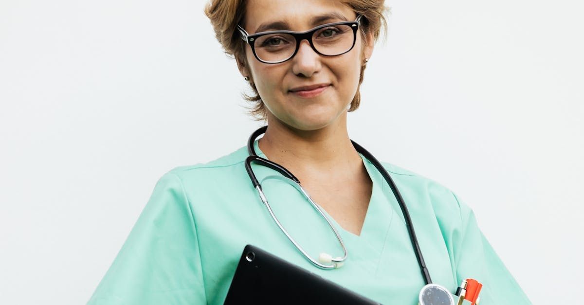 A female doctor wearing glasses and a stethoscope is holding a clipboard.