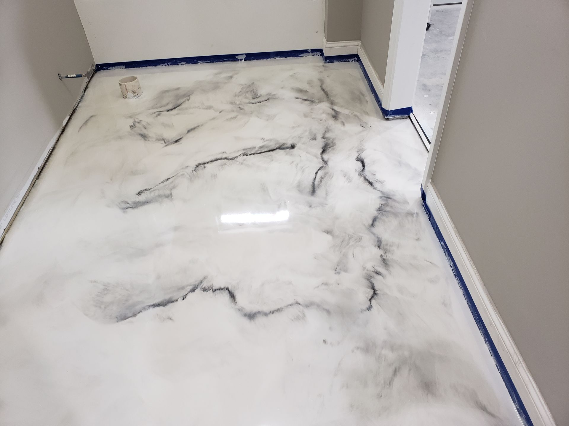 A room with a marble-like epoxy floor in white and gray swirls. Walls are light gray.