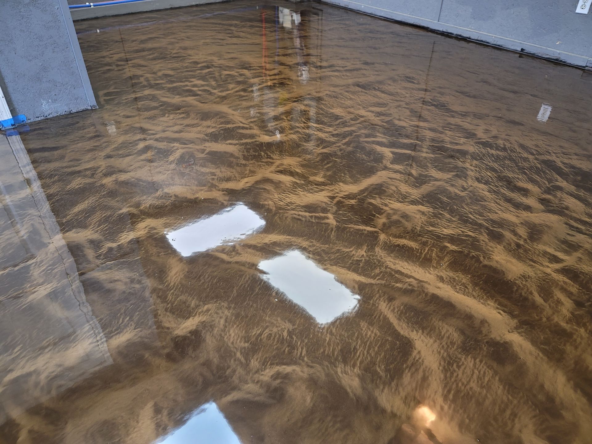 Metallic brown epoxy flooring, reflecting light and creating a marbled effect in a room.