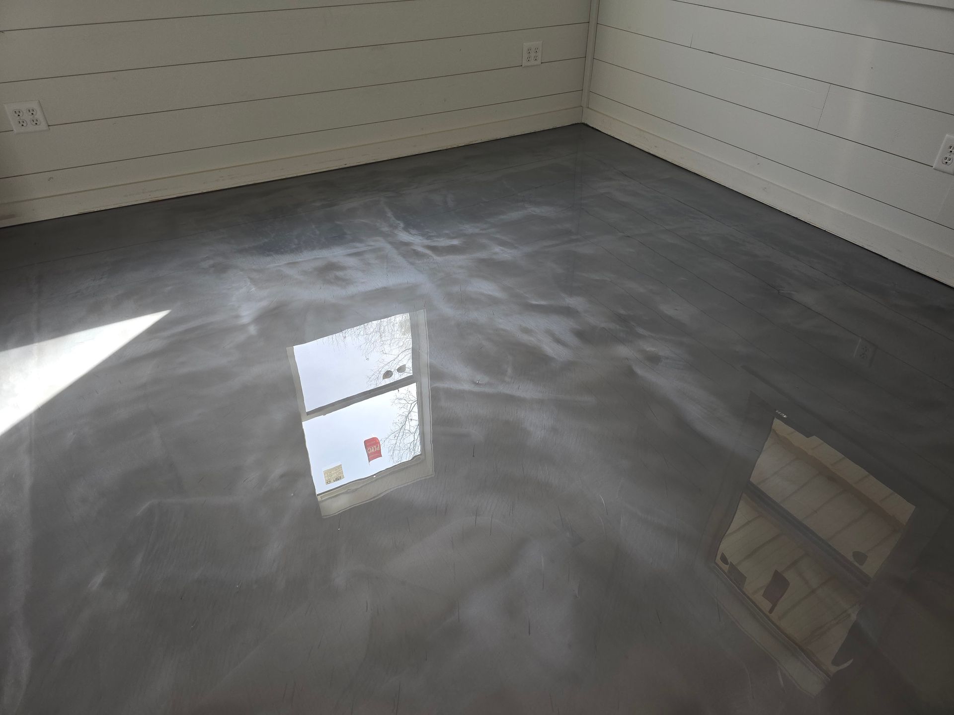 A brown and tan checkered floor with a white fence in the background
