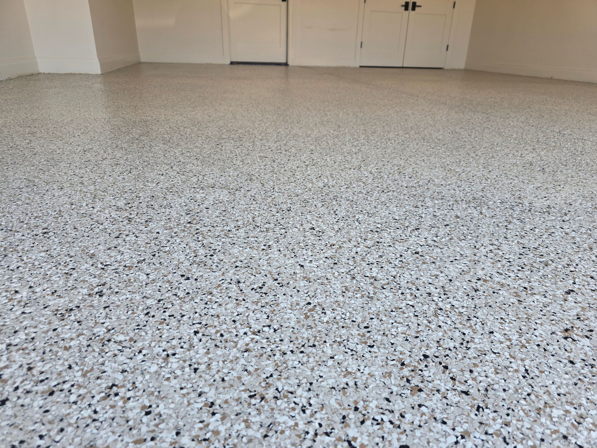 A brown and tan checkered floor with a white fence in the background