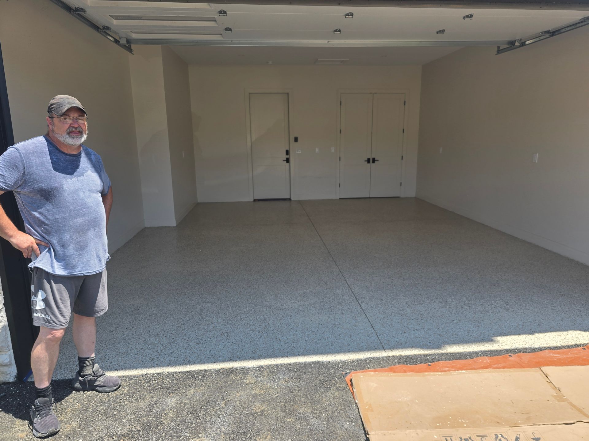 A large concrete floor with a brick wall in the background.
