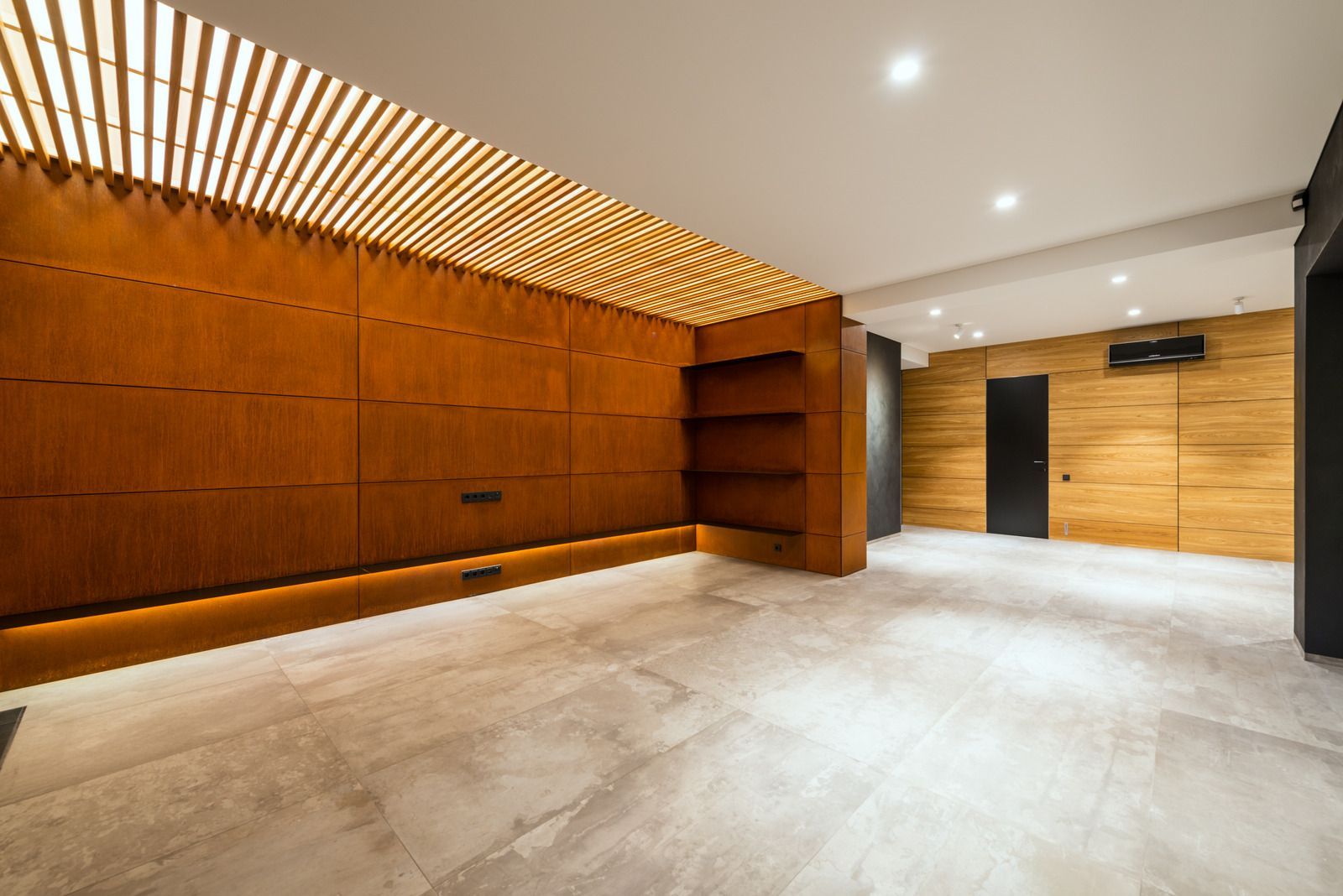 A large empty room with a wooden wall and a tiled floor.