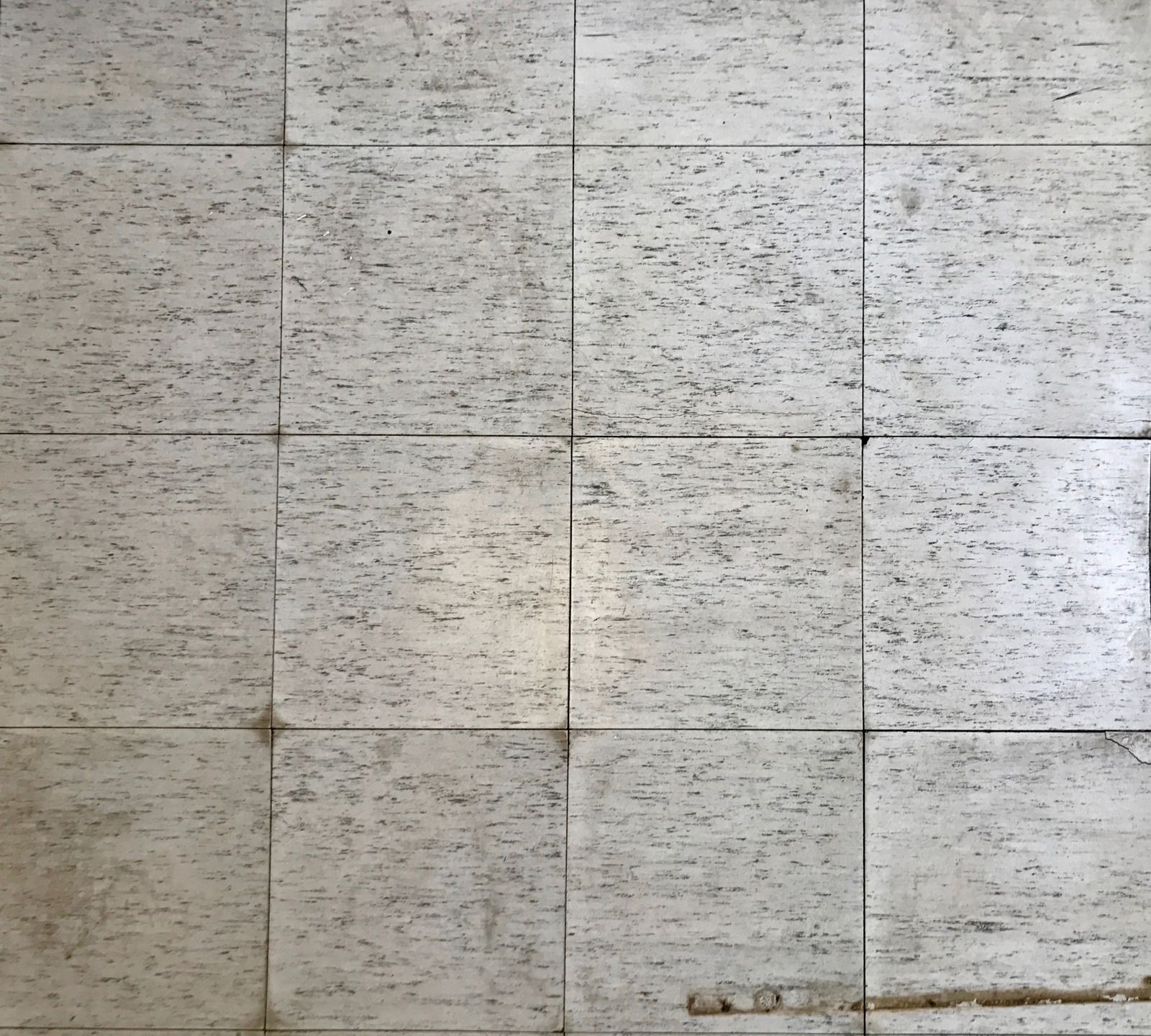 A large empty room with a wooden wall and a tiled floor.