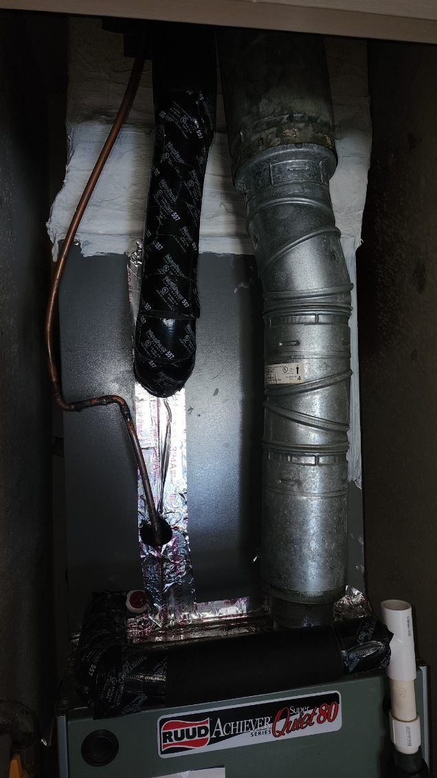 A close up of a furnace with a hose coming out of it.