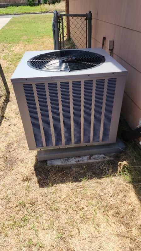 A large air conditioner is sitting on the side of a building.